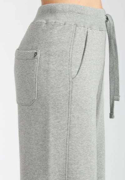 Pantaloni tuta grigi in morbido tessuto a maglia. Presentano una vita elasticizzata, coulisse, tasche laterali e dettagli cuciti lungo le cuciture.