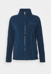 Veste en polaire navy avec une fermeture à glissière complète, un col haut et des coutures bleues contrastantes. Comprend des poches latérales et un petit logo sur la poitrine.