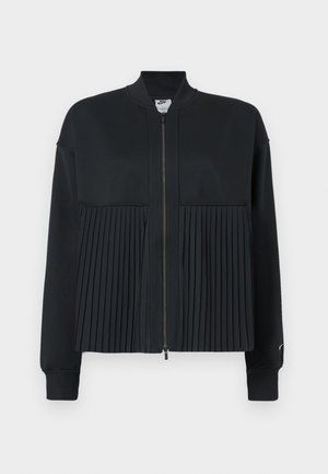 Black jacket with a zip front, featuring a smooth upper section and a pleated lower section. Comprised of soft, stretchable material.