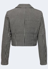 Zkrácená bunda v černobílém houndstooth vzoru, upravený design s dlouhými rukávy a klopovým límcem. Texturovaná tkanina.