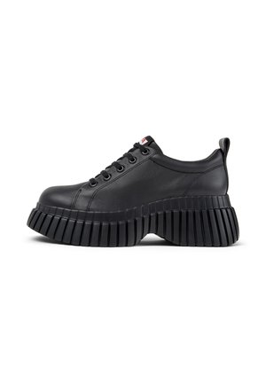 Baskets en cuir noir avec une semelle épaisse et striée et un bout rond. Les caractéristiques comprennent un design à lacets et une petite boucle à l'arrière.