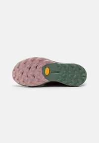Semelle de chaussure de trail en caoutchouc rose et vert, avec des crampons multidirectionnels et un logo Vibram clairement affiché en jaune.