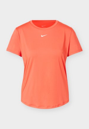 Lyserød koralfarvet kortærmet sportst-shirt med rund halsudskæring og lille hvidt Nike-logo centreret under halsudskæringen, vist på hvid baggrund.