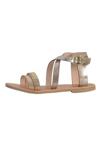 Metalen gouden platte sandalen met dunne kruisbanden en een zijgesp. Soepele leren binnenzool en duurzame platte zool.