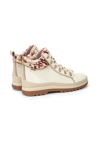 Botas de tobillo de cuero beige con un cuello de piel estampado en rosa y marrón, ojales de metal y suela de goma texturizada marrón.