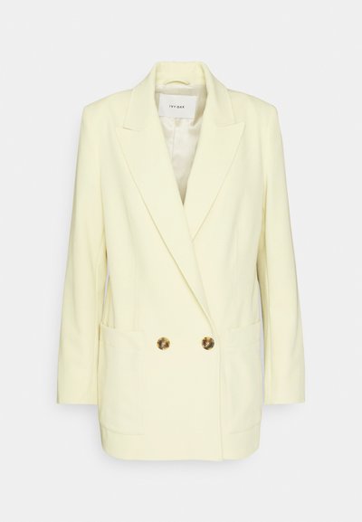 Διπλής όψης σακάκι σε ανοιχτό κίτρινο, με κομψό σχέδιο, αυλακωτούς γιακάδες, δύο μπροστινές τσέπες και κουμπιά σε χρυσό τόνο. Λείος υφασμάτινος σκελετός.