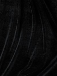 Μαύρο βελούδινο ύφασμα που εμφανίζει λεία υφή και απαλή γυαλάδα, με απαλά πτυχώματα που δημιουργούν μια ρέουσα εμφάνιση.