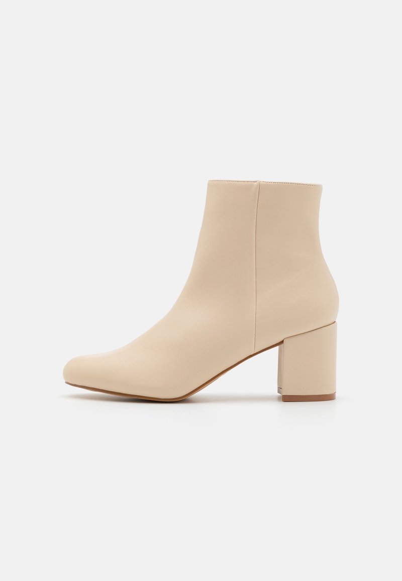 Bottine beige à bout arrondi et talon bloc, en cuir lisse, vue de côté extérieur sur fond blanc uni.
