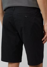 Zwarte katoenen shorts met een rechte snit, twee achterzakken, knopen en een nette zoomafwerking.