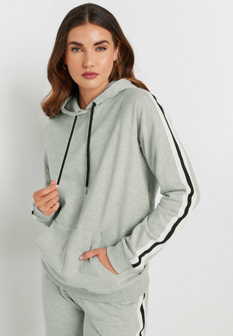 Sudadera gris claro con cordones negros, rayas laterales y un bolsillo frontal. Material suave, corte casual, con puños y dobladillo acanalados.