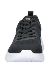 Zapatilla deportiva negra con parte superior de malla transpirable y superficie texturizada, con cordones negros y una suela blanca acolchada.