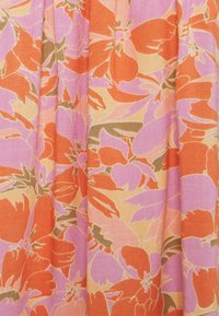 Kwiatowa tkanina z dużymi pomarańczowymi i różowymi kwiatami na jasnopomarańczowym tle. Tekstura jest gładka z delikatnym połyskiem.