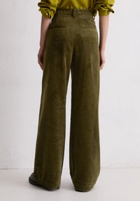 Olijfgroene corduroy broek met wide-leg, verticale ribbelstructuur, hoge taille en twee achterzakken. Gladde, zachte afwerking.