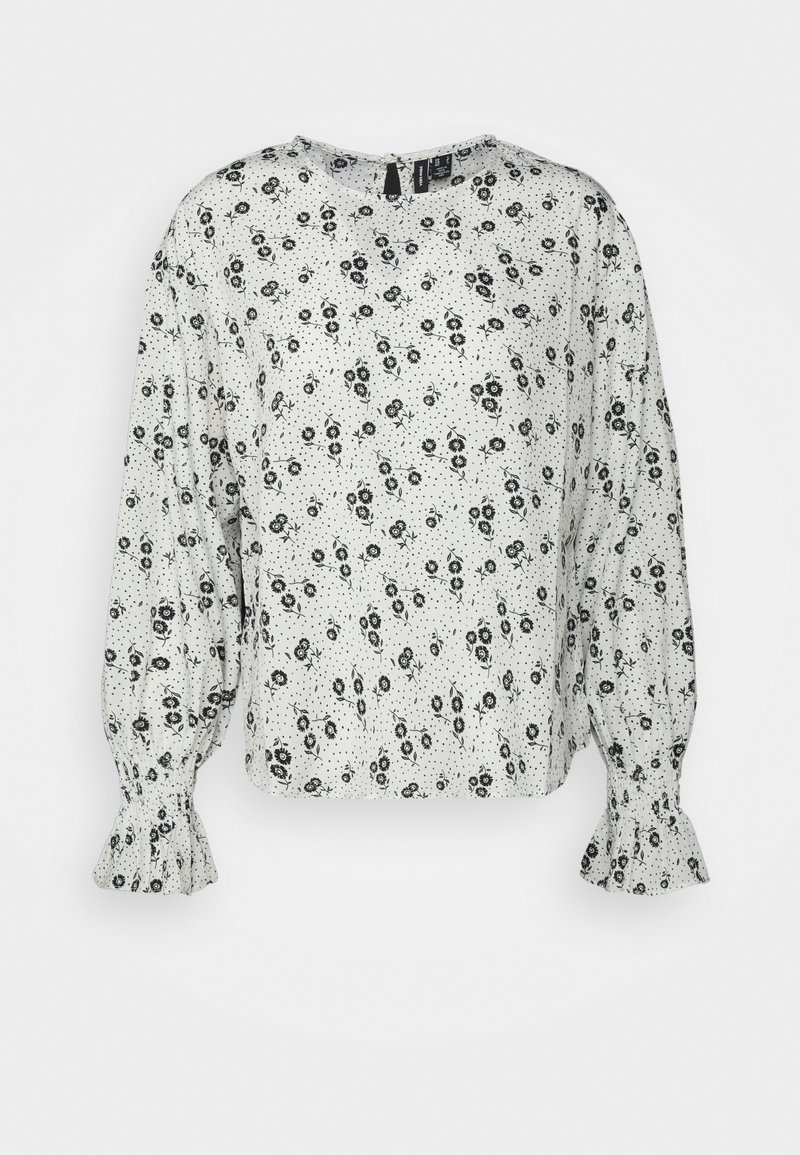 Blusa branca com padrão floral preto, mangas bufantes longas, punhos franzidos e gola redonda. Tecido leve com uma textura suave.