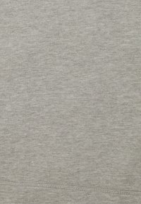 Tejido de sudadera gris claro con una textura suave. Presenta un sutil patrón de jaspeado y costuras a lo largo del dobladillo. Diseño casual y sencillo.