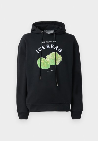 Svart hettegenser med snorer og et fronttrykk av et grønt salatdesign. Har trykt tekst: "GJENNOMSVIKT FOR ISBERG" og "Siden 1974."