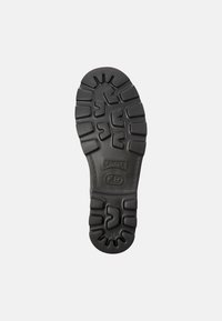 Suola di scarpa in gomma nera con un motivo di battistrada testurizzato, include marchio e informazioni sul modello, progettata per trazione e durata.