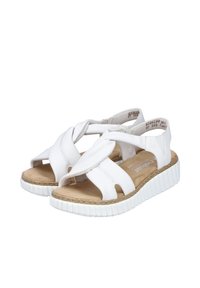 White sandals with a crossed strap design, leather material, flat cork sole, and rubber outsole featuring ridged texture for grip.