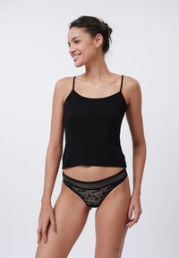 Top negru cu bretele subțiri și chilot negru din dantelă cu model floral. Textură de țesătură netedă, croială ajustată și accente din dantelă plată.