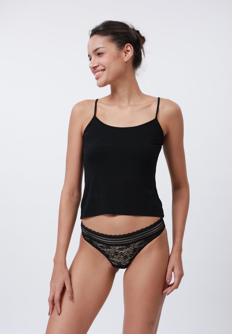 Top negru cu bretele subțiri și chilot negru din dantelă cu model floral. Textură de țesătură netedă, croială ajustată și accente din dantelă plată.