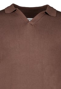 Polo marron en tricot avec col en V et bords de col rabattus, présentant une texture côtelée fine sur le tissu.