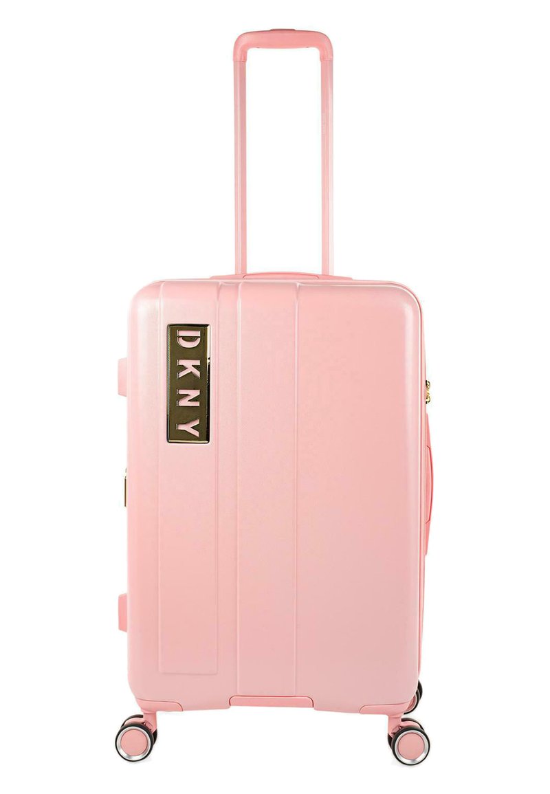 Maleta rígida rosa con ranuras verticales, asa retráctil, cuatro ruedas y un logotipo dorado de DKNY en el lateral. Textura lisa.