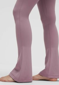 Lágy levendula színű, sima tapintású, harangszárú leggings, oldalsó varrásokkal és kissé széles szegéllyel a bokánál.