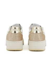 Sneakers bianchi con accenti metallici dorati e sezioni del tallone beige glitterate. Suole spesse, materiali texturizzati e branding in rilievo sul retro.