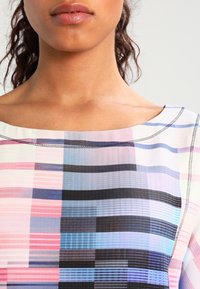 Wielokolorowa bluzka o szerokim dekolcie, z wzorem w paski w kolorach różowym, niebieskim i czarnym, z kontrastowym wykończeniem. Gładka struktura materiału.