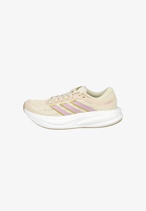 Zapatilla de correr beige clara con rayas rosas, suela blanca acolchada y parte superior de malla para transpirabilidad.