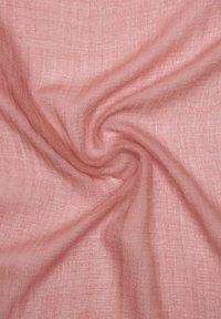 Lekki, teksturowany materiał w jasnoróżowym kolorze, z delikatnym wzorem splotu i miękkim opadającym fasonem, tworzącym subtelne fałdy i spirale.