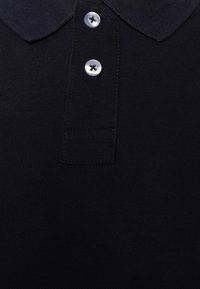 Navy polo shirt featuring a classic collar, two silver buttons, and textured fabric. The design is simple and functional.