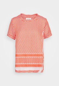 Bílý tričko s krátkým rukávem s oranžovým geometrickým vzorem, kulatým výstřihem a visačkou s nápisem "CECILIE" uvnitř límce.