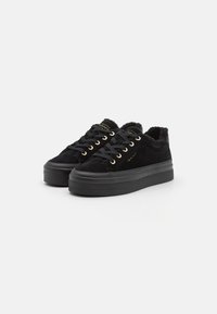 Schwarze Wildledersneaker mit einer klobigen schwarzen Sohle, goldenen Ösen und einem flauschigen Futter. Verfügt über ein klassisches Schnürdesign.