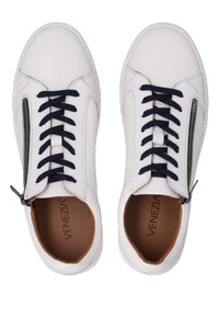 Hvide læder sneakers med marineblå snørebånd, detaljer med lynlås på siden og brun inderside. Glat tekstur med rund tå design.