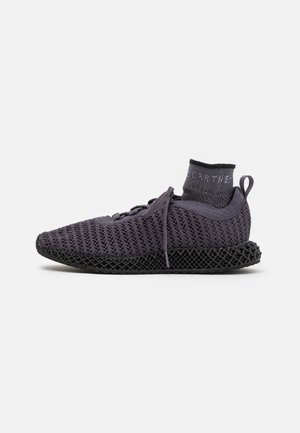 Zapatillas deportivas moradas de malla con un cuello similar a un calcetín, que presentan una parte superior texturizada y una entresuela de rejilla negra para soporte y transpirabilidad.