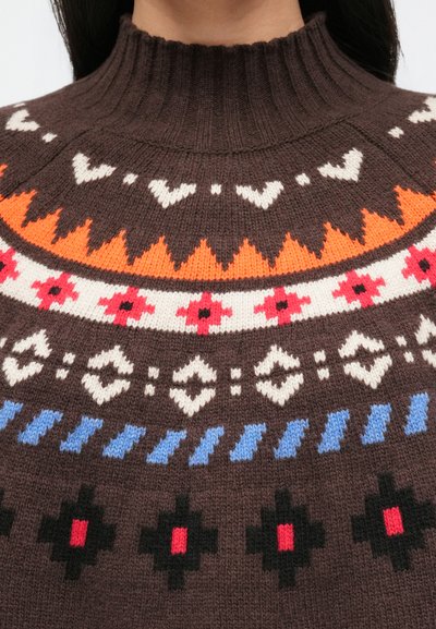 Pruun kootud kampsun kõrge kraega, mille ees on valge, oranži, punase, sinise ja musta geomeetriliste ja lillemustritega rind.