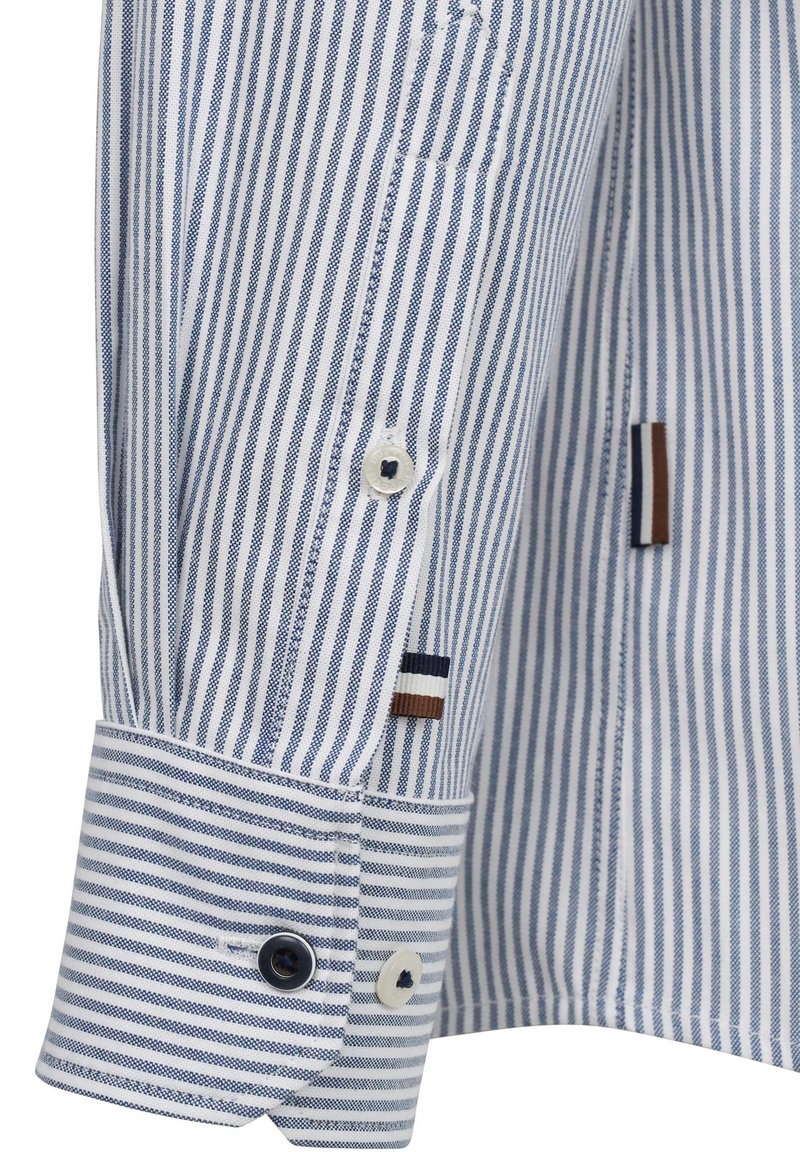 Poignet de chemise rayé bleu et blanc avec un trou de bouton contrastant, arborant des accents colorés et des boutons supplémentaires pour le détail.