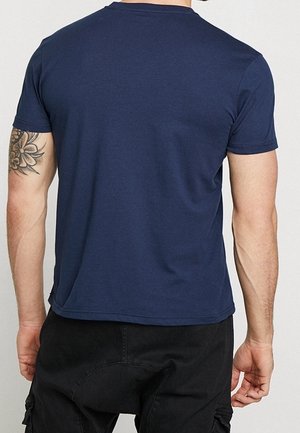 Maglietta in cotone blu navy con maniche corte, scollo tondo e design posteriore senza cuciture. Tessuto liscio senza motivi o grafiche visibili.