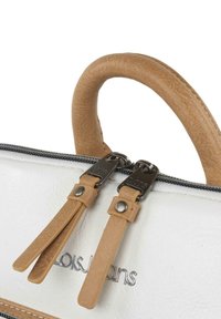 Bolso blanco con asas de cuero sintético marrón y tiradores de cremallera. Logotipo plateado en el exterior, textura suave y detalles de costura finos visibles.