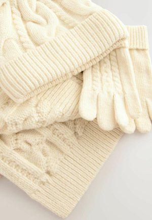 Set aus cremefarbenen Winteraccessoires, bestehend aus einer kabelstrickmütze, handschuhen und einem schal, mit einem strukturierten Rippdesign.