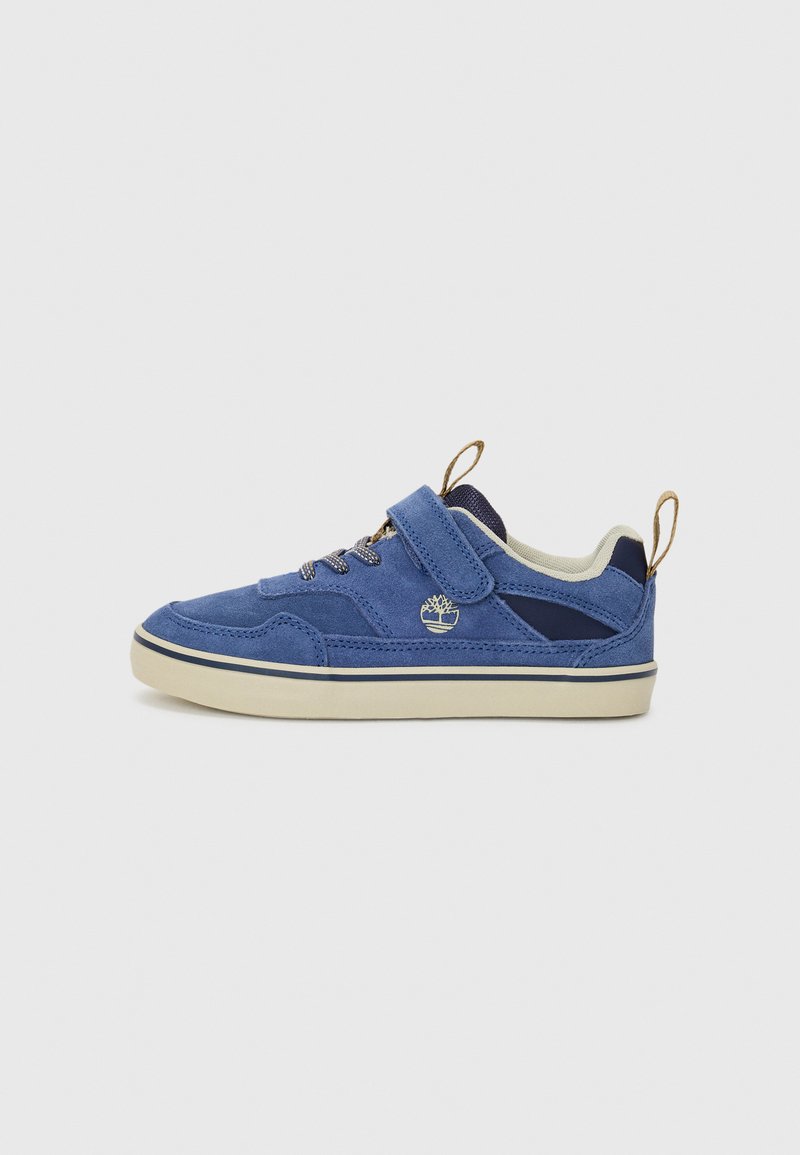 Baskets en suede bleu avec une semelle en caoutchouc plate, doublure en textile, une sangle Velcro et un logo décoratif sur le côté. Présente un design de lacets contrastants.