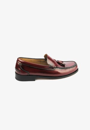 Mocasin de piel burdeos con un acabado suave, borlas decorativas en la parte superior y un ribete cosido. Suela de goma negra, diseño de fácil colocación.