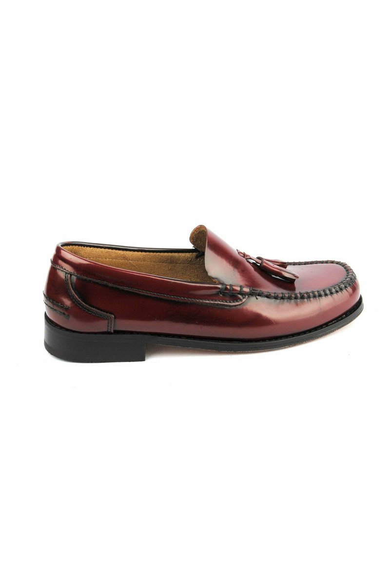 Mocasin de piel burdeos con un acabado suave, borlas decorativas en la parte superior y un ribete cosido. Suela de goma negra, diseño de fácil colocación.