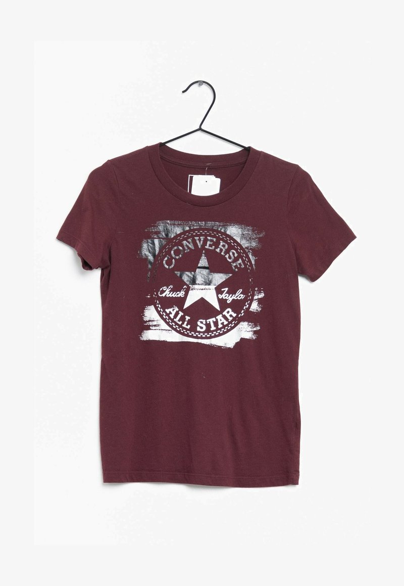 T-shirt en coton bordeaux avec un col rond, présentant un graphisme blanc usé d'une étoile et le texte "Converse All Star" dans un design circulaire.