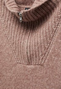 Maglione lavorato a maglia rosa chiaro con colletto alto, dotato di una breve cerniera e texture a coste. Il tessuto sembra morbido e spesso.