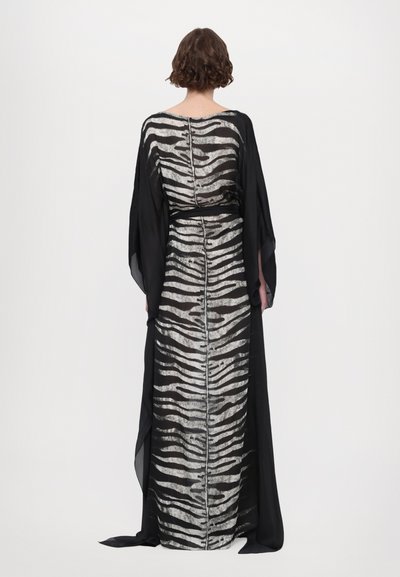 Îmbrăcăminte lungă de culoare neagră, cu manșete diafane și fluide; prezintă un model zebra în dungi argintii și negre; textură netedă, scoate în evidență talia cu o curea.