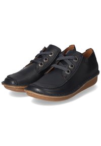 Zapatos de cuero negro con puntera redondeada, cordones grises a través de ojales metálicos y una suela de goma marrón claro. Costuras visibles que acentúan.