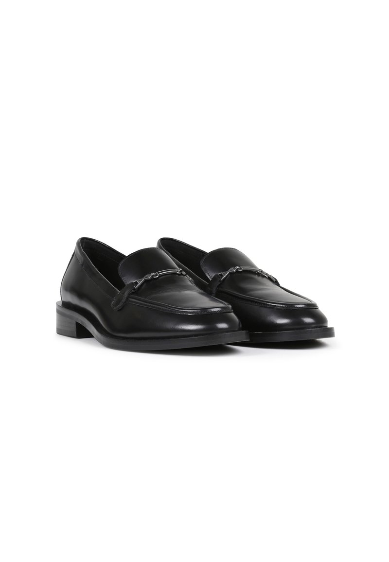 Mocassins en cuir noir au design épuré, dotés d'un talon plat et d'une accentuation en chaîne sur le devant. Texture lisse et forme classique.