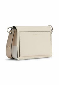 Sac bandoulière Calvin Klein en cuir crème au design structuré, doté d'une poche avant, de garnitures argentées et d'une sangle réglable.